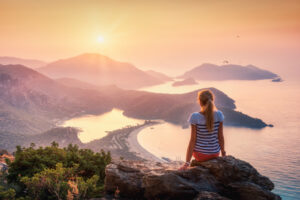 young-woman-sitting-on-the-top-of-rock